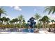 Resort-style pool featuring a water slide, lounge chairs, palm trees, and ample space for relaxation and recreation at 1672 Valier Pt, Zephyrhills, FL 33541