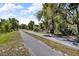 Long shot of a road lined with green grass and trees at 1796 Harbor Dr, Clearwater, FL 33755