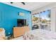 Cozy bedroom featuring a balcony, modern furnishings, and a bright blue accent wall at 18399 Gulf Blvd # 389, Indian Shores, FL 33785