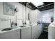 Well-equipped laundry room with multiple washers, dryers, and convenient shelving for laundry essentials at 18399 Gulf Blvd # 389, Indian Shores, FL 33785