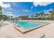 A community pool surrounded by lush landscaping provides a relaxing oasis for residents under a bright blue sky at 18399 Gulf Blvd # 389, Indian Shores, FL 33785