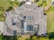 Aerial view of a unique estate showing the screen enclosed in-ground pool and intricate roof design at 19005 Cour Ests, Lutz, FL 33558