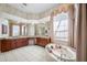 Elegant Primary bathroom with a jetted tub, large windows, and a dual sink vanity at 19005 Cour Ests, Lutz, FL 33558