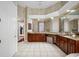 Bathroom with dual vanity, tiled floors, and adjoining dressing area at 19005 Cour Ests, Lutz, FL 33558