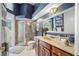 Charming bathroom features a wood vanity, marble countertop, and a tiled glass shower at 19005 Cour Ests, Lutz, FL 33558