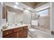 Well-lit bathroom featuring a single vanity and a shower-tub combo with glass doors at 19005 Cour Ests, Lutz, FL 33558
