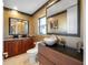 Well-lit bathroom with a unique vessel sink, wooden cabinets, and decorative accents at 19005 Cour Ests, Lutz, FL 33558