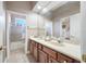 Bright bathroom with dual sinks, wood cabinets, and convenient access to the shower and bedroom at 19005 Cour Ests, Lutz, FL 33558