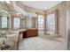 Luxurious bathroom features a jetted tub, dual sinks, and large windows with elegant curtains at 19005 Cour Ests, Lutz, FL 33558