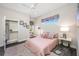 Cozy bedroom featuring a plush rug, pink bedding, and ample natural light from the windows at 19005 Cour Ests, Lutz, FL 33558