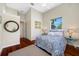 Cozy bedroom featuring hardwood floors, ceiling fan, and lots of natural light from the large window at 19005 Cour Ests, Lutz, FL 33558