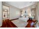 Stylish bedroom featuring hardwood floors, neutral decor, and an open entrance to the bathroom at 19005 Cour Ests, Lutz, FL 33558