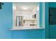Open kitchen view with pass-through window, showcasing white cabinets, stainless steel appliances, and quartz countertops at 1901 66Th N Ave, St Petersburg, FL 33702