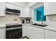 Updated kitchen featuring stainless steel appliances, white cabinets, quartz countertops, and a modern black sink fixture at 1901 66Th N Ave, St Petersburg, FL 33702