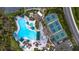 Expansive aerial view of a pool and tennis courts surrounded by lush landscaping at 1922 Sifield Greens Way # 47, Sun City Center, FL 33573