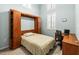Cozy bedroom featuring a murphy bed, built in bookcase, and a dedicated workspace with natural light at 1922 Sifield Greens Way # 47, Sun City Center, FL 33573