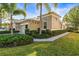 Charming single-Gathering home featuring stucco exterior and well-manicured landscaping with palm trees at 1922 Sifield Greens Way # 47, Sun City Center, FL 33573
