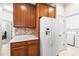 Kitchen featuring wooden cabinets, white appliances, and access to the laundry room at 1922 Sifield Greens Way # 47, Sun City Center, FL 33573