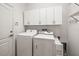 Well-lit laundry room with white cabinets, washer, and dryer at 1922 Sifield Greens Way # 47, Sun City Center, FL 33573