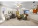 Open-concept living room with neutral carpet, comfortable seating, and view into dining and kitchen at 1922 Sifield Greens Way # 47, Sun City Center, FL 33573