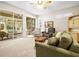 Bright living room with neutral carpet, comfortable seating, and view of the screened lanai at 1922 Sifield Greens Way # 47, Sun City Center, FL 33573