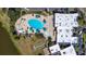 Aerial view of large community pool with lounge area, adjacent to building and greenspace at 1922 Sifield Greens Way # 47, Sun City Center, FL 33573