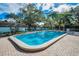 Beautiful community pool offering a refreshing oasis surrounded by palm trees and greenery at 200 Glennes Ln # 201, Dunedin, FL 34698