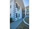 The exterior of the building has a charming architectural style, nice landscaping, and stairs leading to the units at 200 Glennes Ln # 201, Dunedin, FL 34698