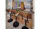 Kitchen bar area with three chairs and a granite countertop that offers a view into the kitchen area at 200 Glennes Ln # 201, Dunedin, FL 34698