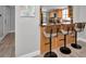 Kitchen bar area with three chairs and a granite countertop that offers a view into the kitchen at 200 Glennes Ln # 201, Dunedin, FL 34698