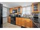 Traditional kitchen with wooden cabinets, black appliances, granite countertops, and a bright window at 200 Glennes Ln # 201, Dunedin, FL 34698