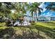 Inviting community pool area with lounge chairs, surrounded by lush trees at 200 Glennes Ln # 201, Dunedin, FL 34698