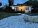 Backyard featuring stone fire pit, a walkway, patio, and manicured lawn, ideal for outdoor activities at 205 N Westland Ave, Tampa, FL 33606