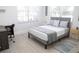 Bedroom featuring gray headboard bed, white and gray bedding, a desk, chair, and a large window at 205 N Westland Ave, Tampa, FL 33606