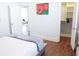 Bright bedroom featuring wood floors, white walls, a closet and a doorway view to the living room at 205 N Westland Ave, Tampa, FL 33606