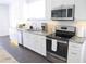 Modern kitchen featuring stainless steel appliances, granite countertops, and white cabinetry at 205 N Westland Ave, Tampa, FL 33606