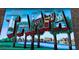 Colorful and large Tampa mural with city scenes depicted within the letters, tall palm trees at 205 N Westland Ave, Tampa, FL 33606