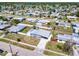 A high aerial view showcasing the home with metal roof, fenced yard, trailer, and manicured lawn at 21298 Austin Ave, Port Charlotte, FL 33952
