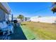 Spacious backyard with a white fence, green lawn, shed, patio, and patio furniture at 21298 Austin Ave, Port Charlotte, FL 33952
