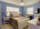 Cozy bedroom with blue walls, a white bed frame, and soft lighting, creating a serene atmosphere at 21298 Austin Ave, Port Charlotte, FL 33952