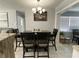 Dining area featuring a wooden table, upholstered chairs, and a modern chandelier at 21298 Austin Ave, Port Charlotte, FL 33952