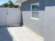 Side exterior of home with a gray stucco wall and a white vinyl privacy fence at 21298 Austin Ave, Port Charlotte, FL 33952