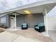 Inviting front porch featuring gray walls, modern light fixture, and two comfortable blue chairs at 21298 Austin Ave, Port Charlotte, FL 33952