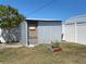 A metal storage shed in a grassy backyard with a small tree and white vinyl fence at 21298 Austin Ave, Port Charlotte, FL 33952