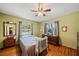 Bedroom featuring light green walls, wood floors and a traditional ceiling fan at 2207 W Ohio Ave, Tampa, FL 33607