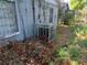 The image shows an outside air conditioner with vines and foliage in need of yard maintenance at 2610 E 26Th Ave, Tampa, FL 33605