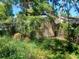 The image shows a backyard with a fence and some foilage, in need of landscaping at 2610 E 26Th Ave, Tampa, FL 33605