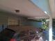 The image shows a carport with a car under it, in need of cleaning and maintenance at 2610 E 26Th Ave, Tampa, FL 33605