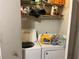 Functional laundry area with stacked washer and dryer and shelf storage at 2610 E 26Th Ave, Tampa, FL 33605
