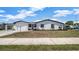 Home exterior featuring textured walls, dark accents, a carport, and well-maintained lawn at 2702 W Braddock St, Tampa, FL 33607